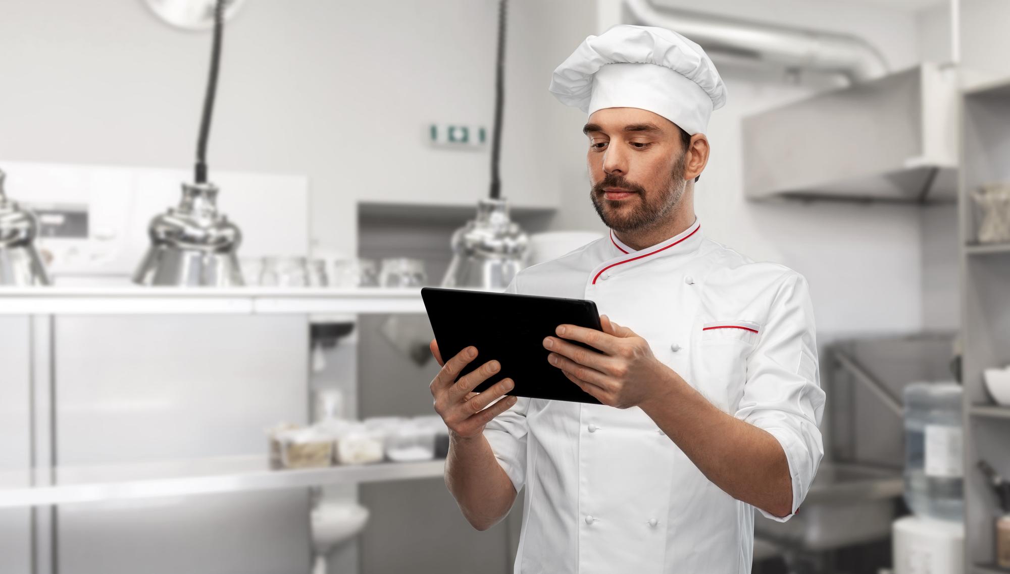 chef checking data on tablet in kitchen